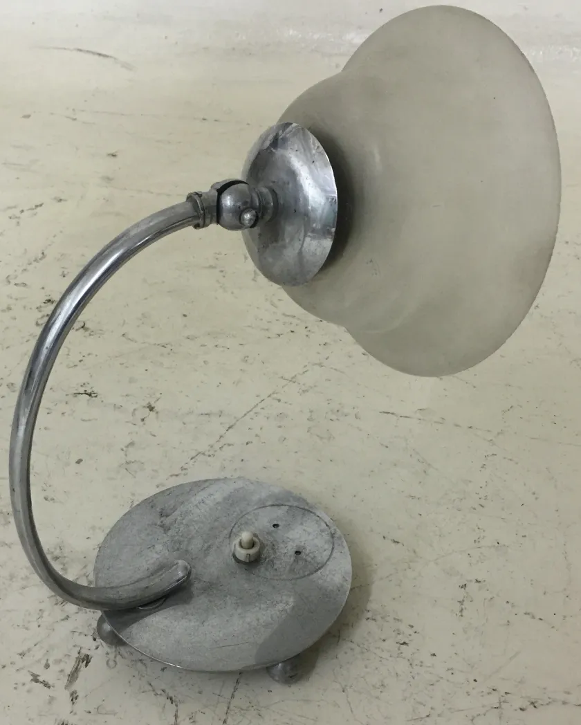 alte tischlampe mit runder basis und gebogenem schirm in neutraler umgebung