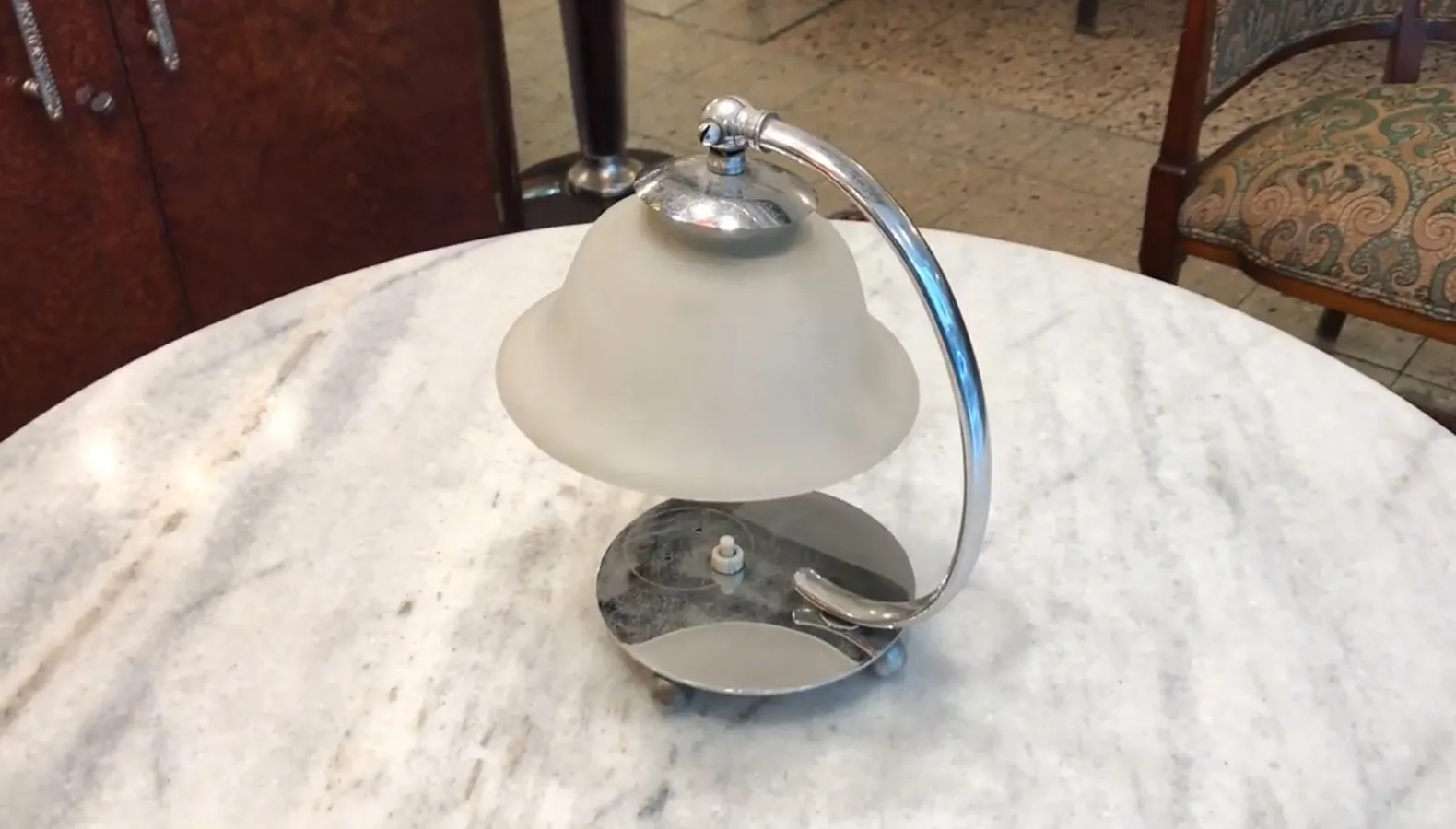 Lampada da tavolo antica di Jean Perzel con luce soffusa in un ambiente classico.