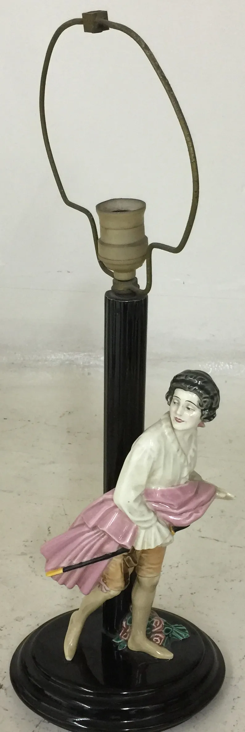 Antica lampada da tavolo con figura decorativa e base nera.
