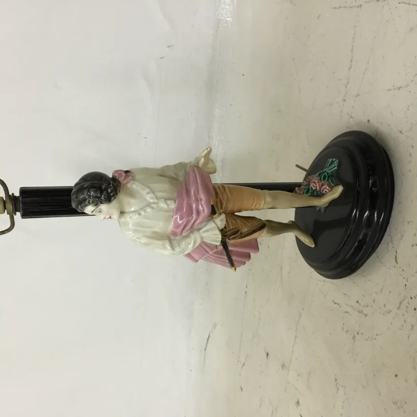 Antique table lamp with decorative figurine, elegant base, and floral details.