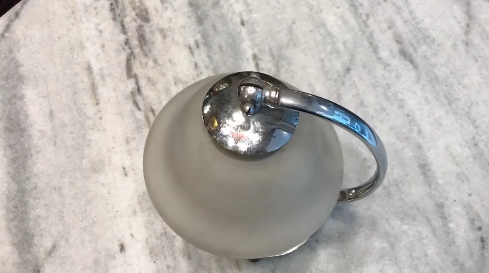 빛나는 베이스의 오래된 테이블 램프가 밝은 표면 위에 장식적으로 놓여 있다