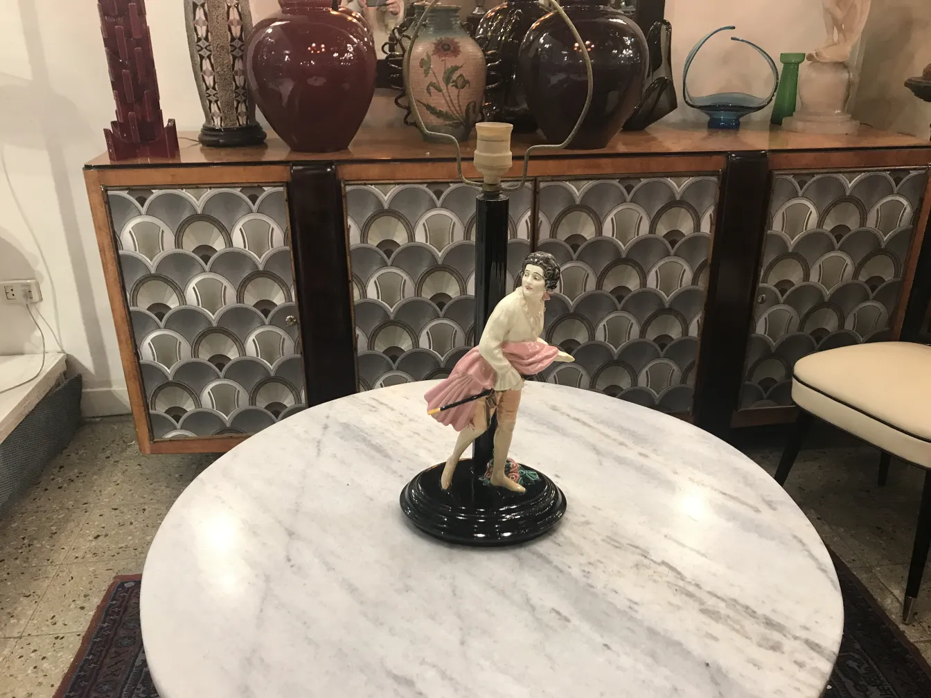 Antique table lamp featuring a decorative figurine at the base.