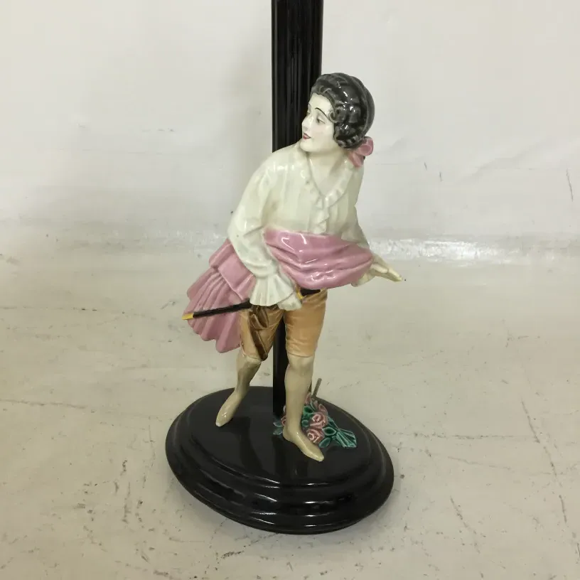 Antike Tischlampe mit Figur, die einen Regenschirm in einem klassischen Setting hält.