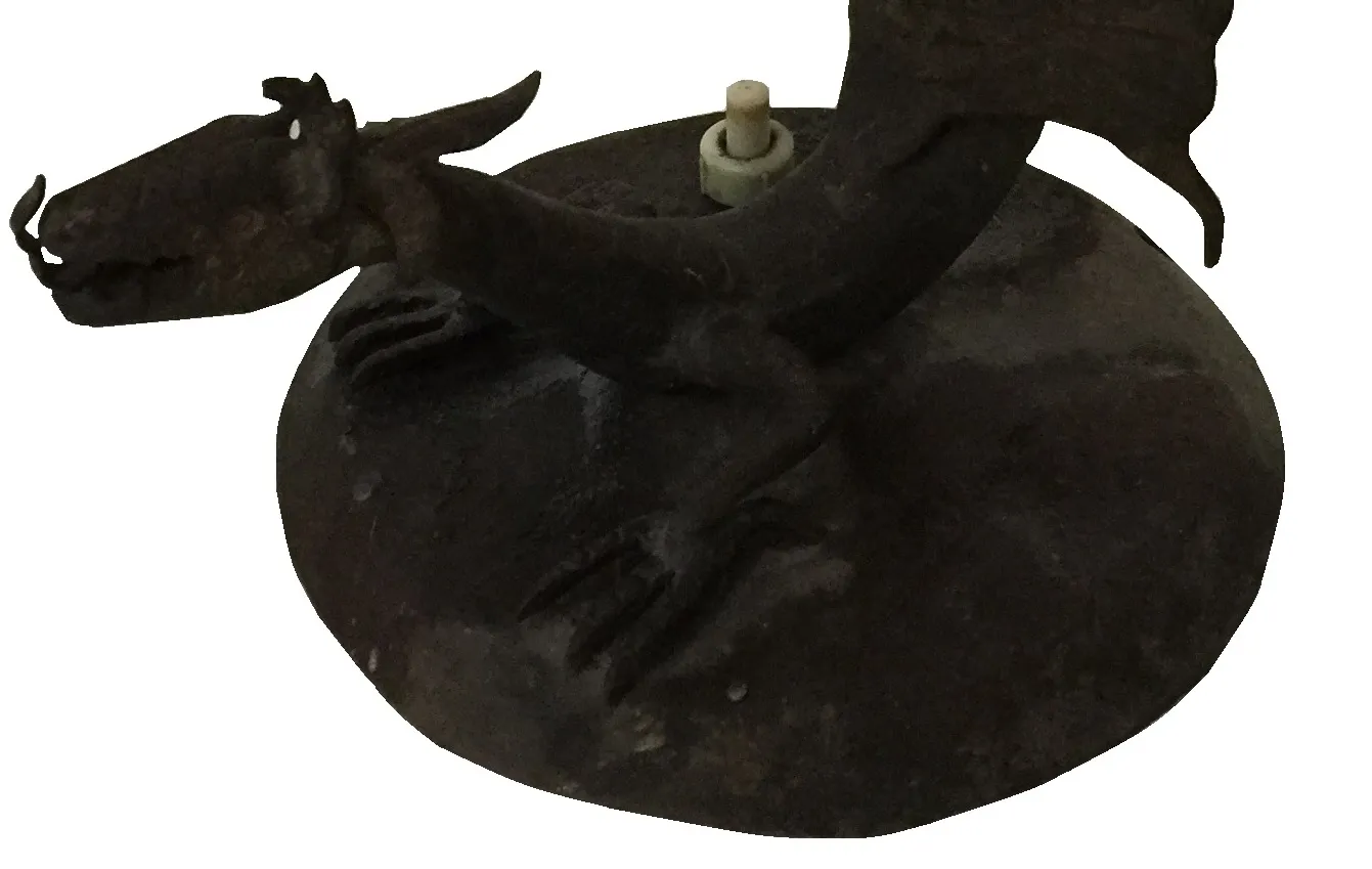 Luminária de mesa antiga em forma de dragão, base redonda, detalhes na superfície.