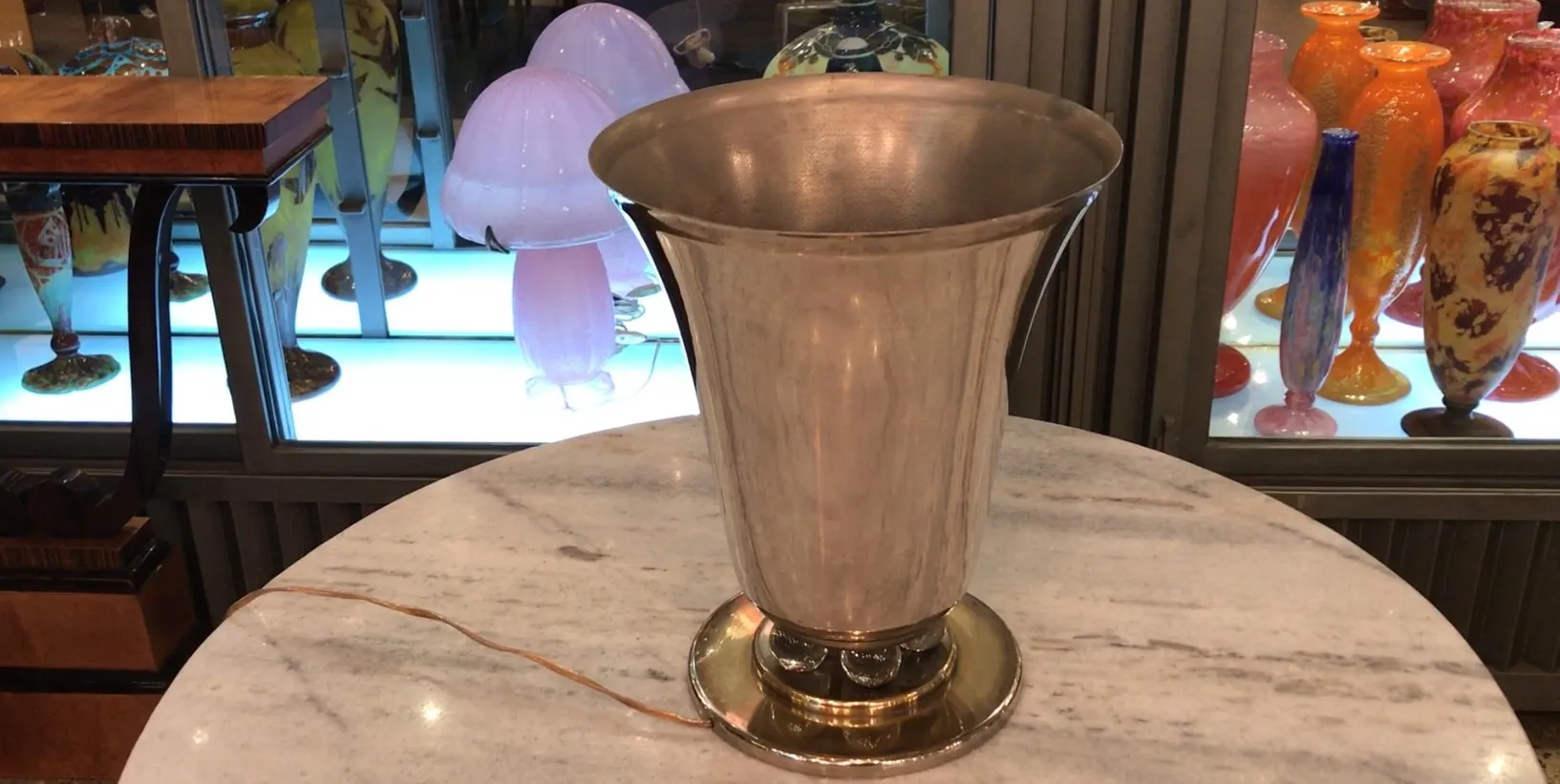 古いテーブルランプ、光沢のある仕上げ、カラフルな装飾品の横に。