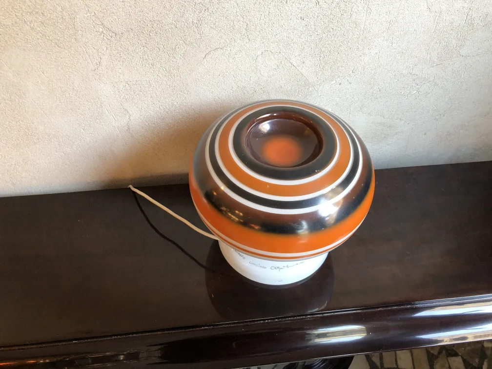 lampara de mesa antigua con forma esferica y colores vivos en un ambiente hogareño