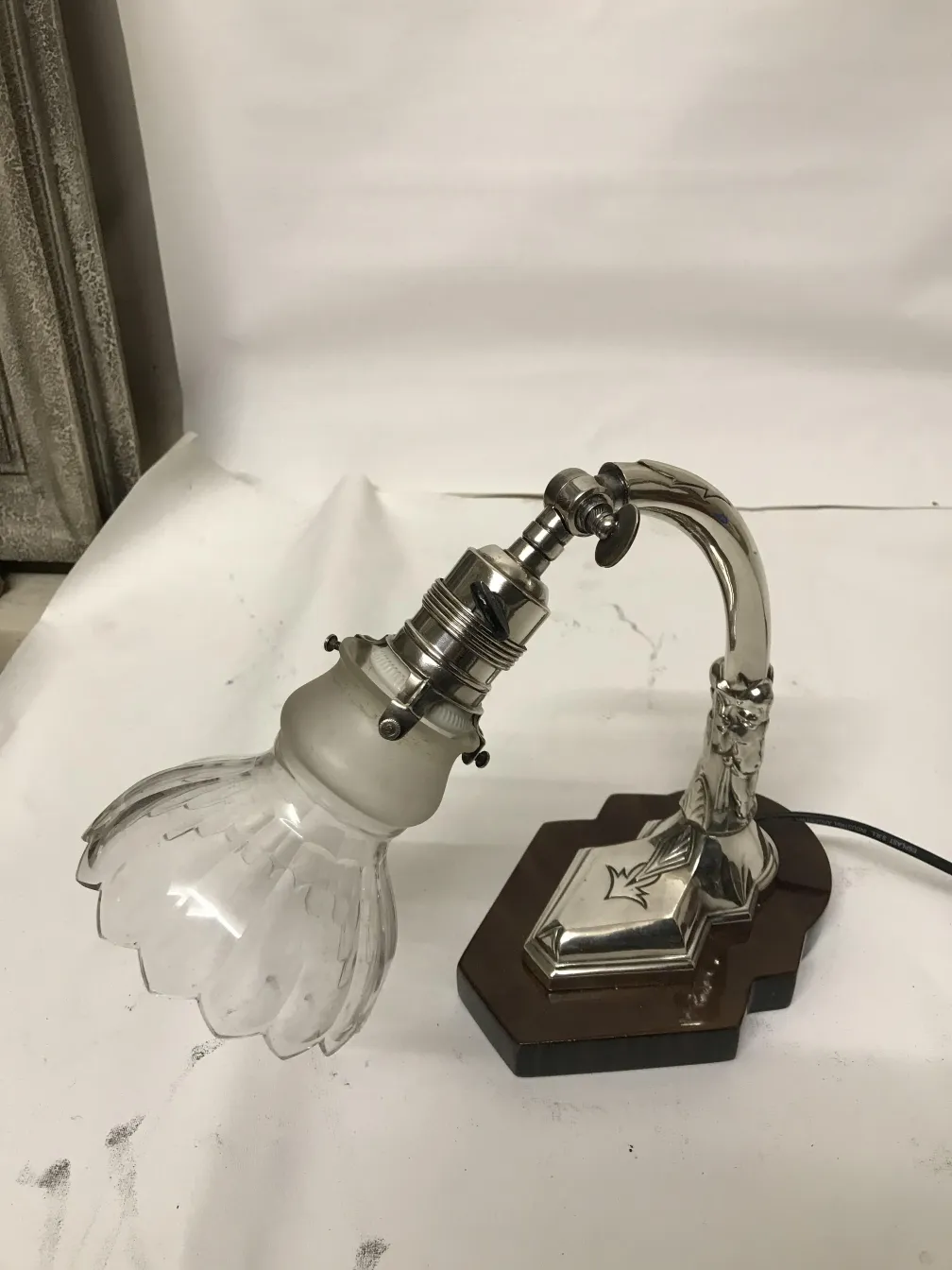 Antike Tischlampe mit elegantem Design und Glasschirm in neutraler Umgebung.