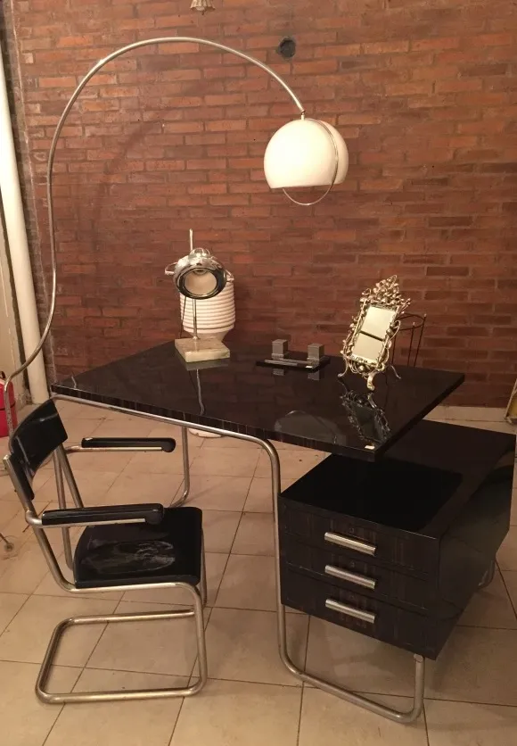 lampara de mesa antigua con base elegante y luz suave, en un escritorio de estilo moderno, rodeada de accesorios de oficina