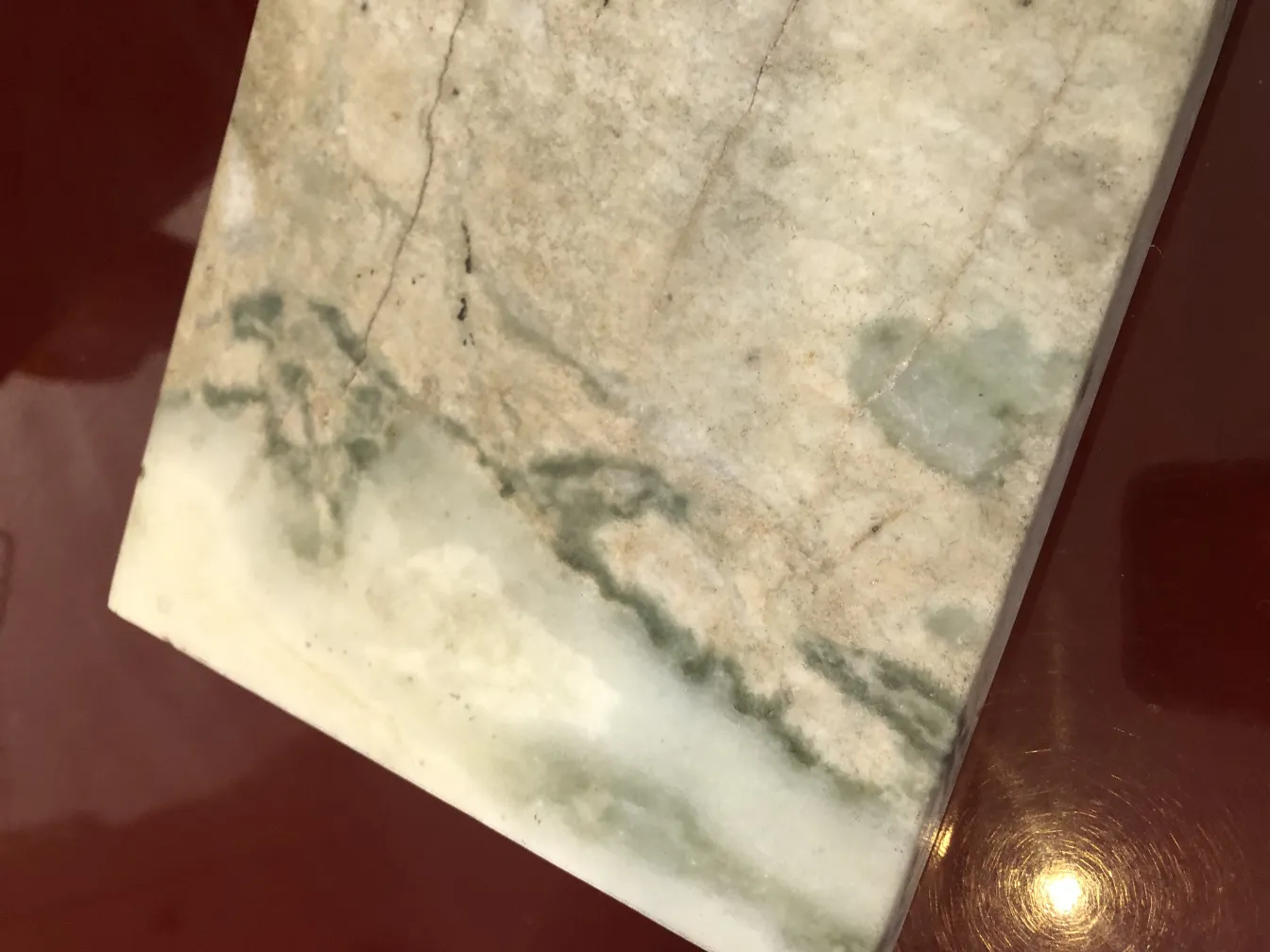 Antigua lámpara de mesa con base decorativa y detalles verdes, ambiente acogedor