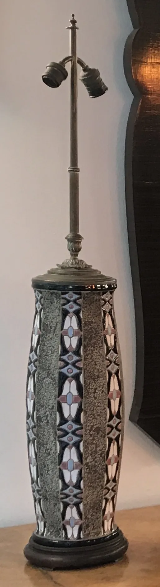 lámpara de mesa antigua decorada con patrones artísticos en un ambiente cálido