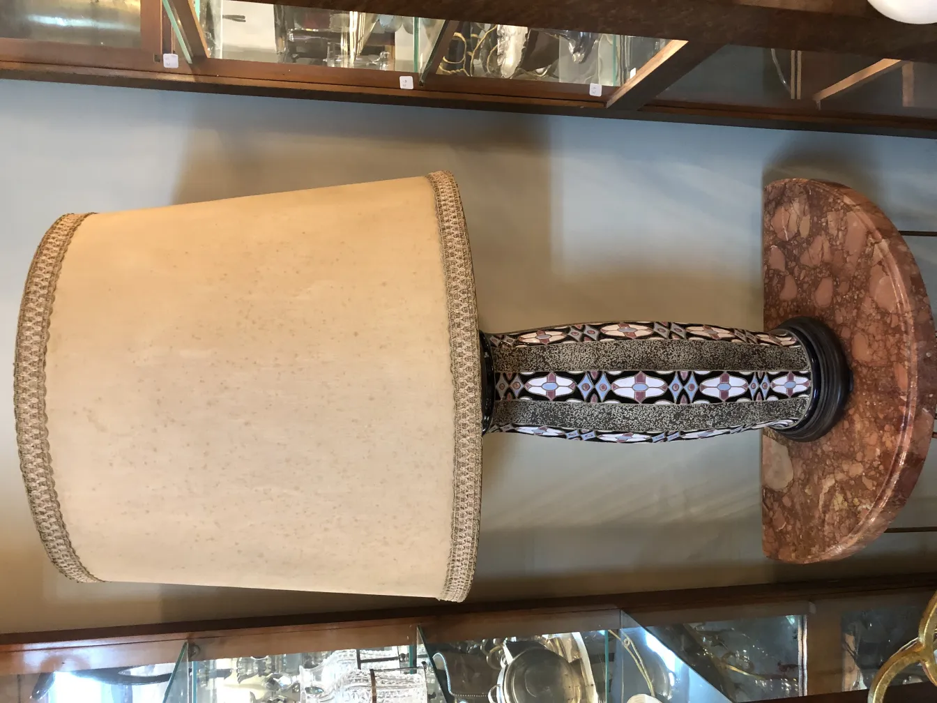 lampada da tavolo antica con paralume beige e base decorativa scura, in un ambiente antico