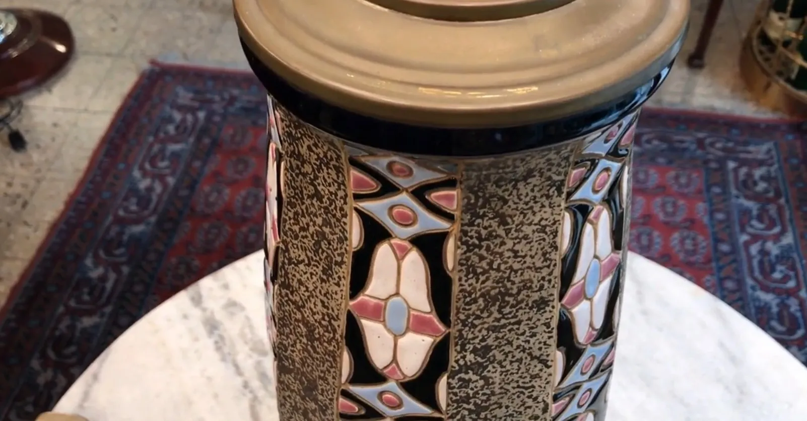 Lámpara de mesa antigua decorativa con diseño colorido en un entorno acogedor