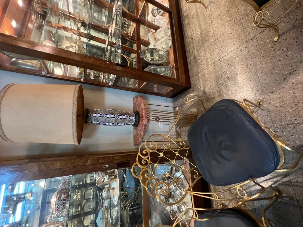 lampara de mesa antigua con base decorativa y pantalla beige, en ambiente con muebles elegantes