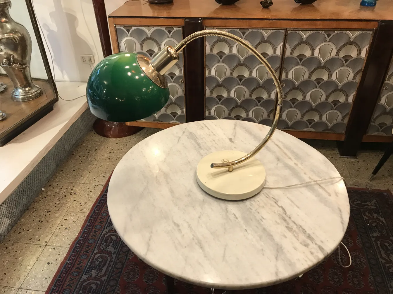 Antike Tischlampe mit heller Basis und grünem Schirm in einem gemütlichen Ambiente.