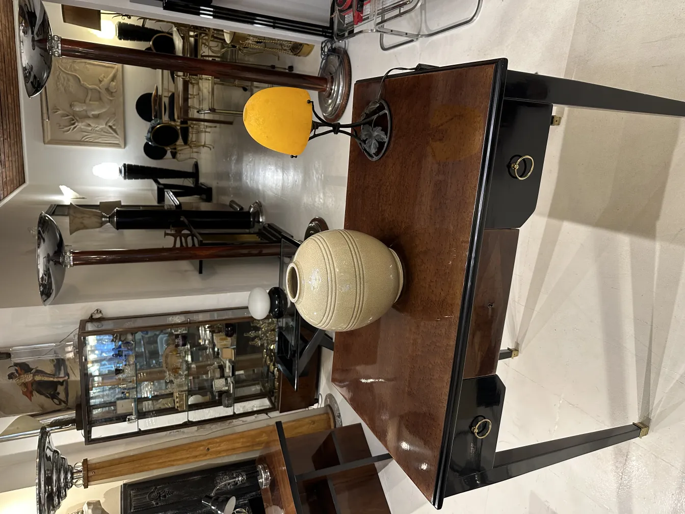 Antiga luminária de mesa amarela em um ambiente acolhedor com objetos decorativos.