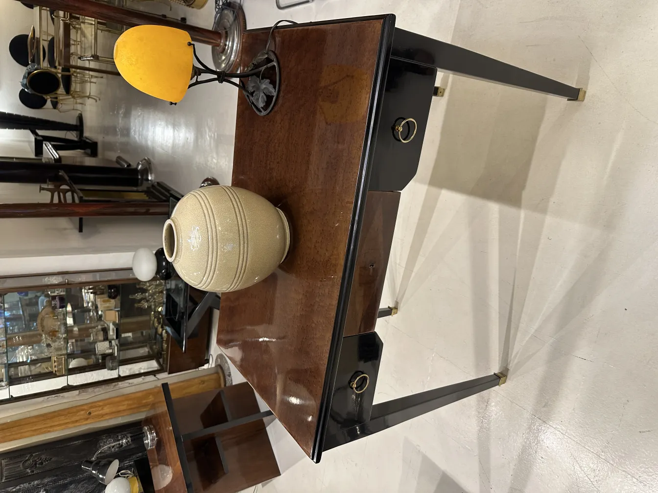 Lampe de bureau ancienne avec base décorative et lumière jaune, dans un environnement d'antiquités.