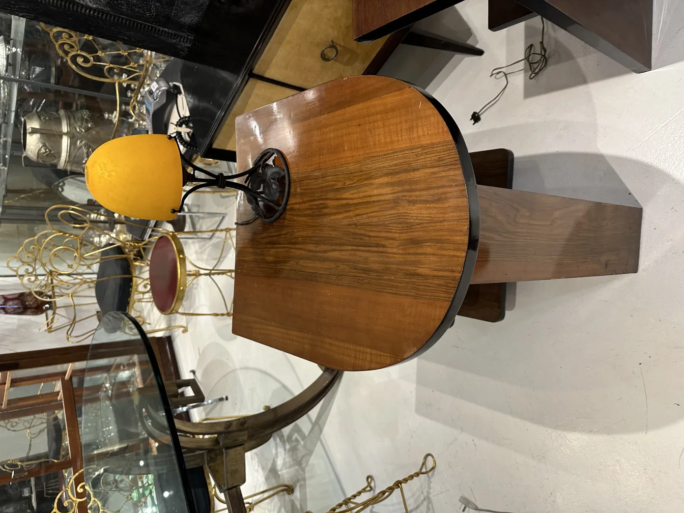 Antike Tischlampe mit rundem gelbem Schirm auf einem Holztisch