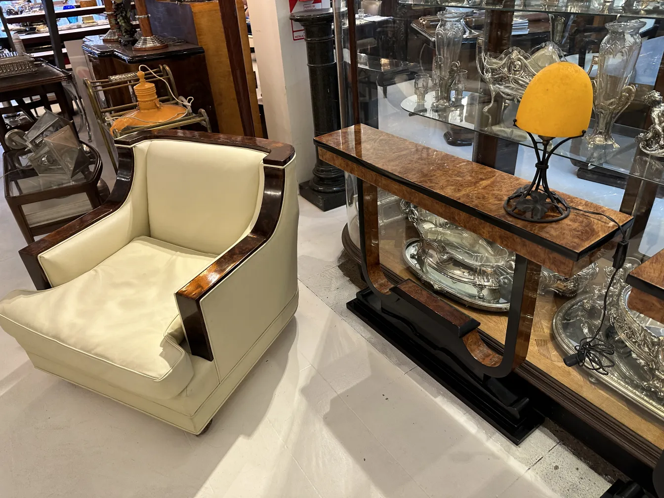 Lámpara de mesa antigua de base negra con forma elegante, en un ambiente con muebles vintage.