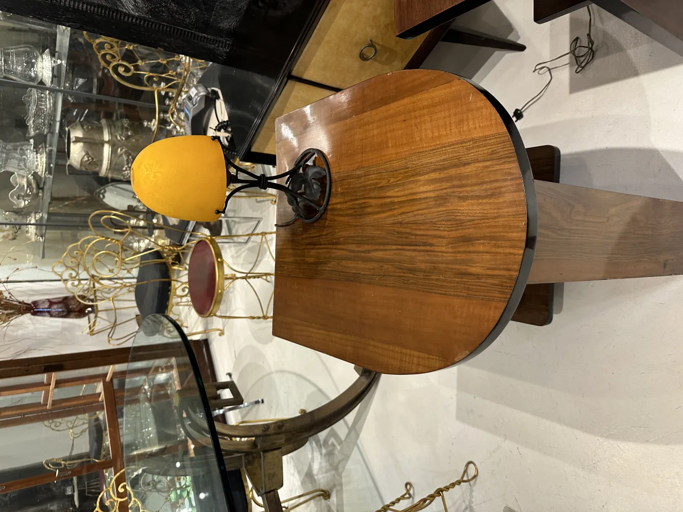 Lampe de bureau ancienne avec base noire et abat-jour jaune, dans un cadre d'antiquités.