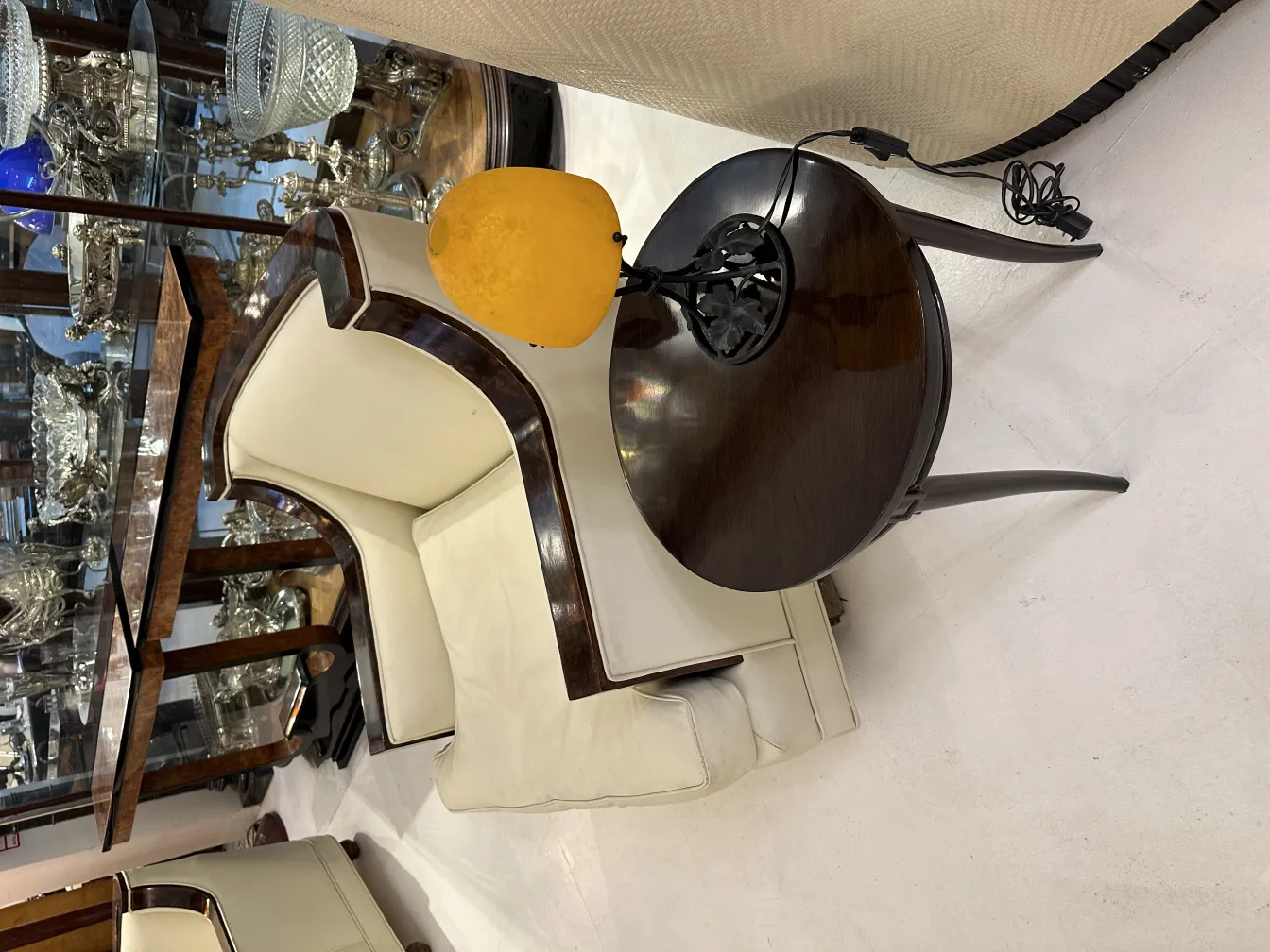 Luminária de mesa antiga com base preta e abajur amarelo, iluminação suave em um ambiente elegante.