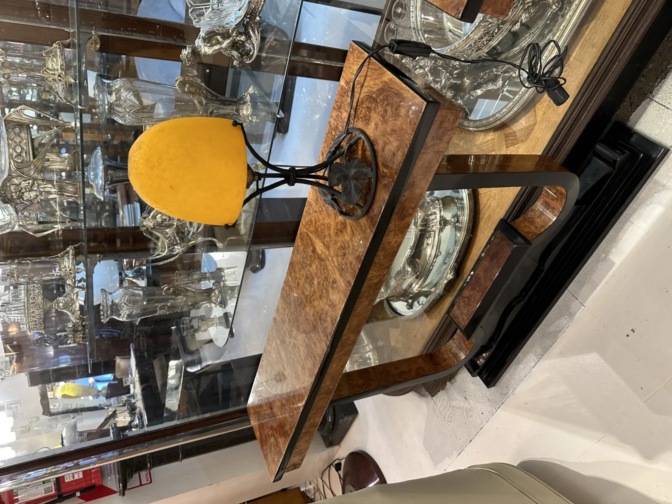 Antique table lamp with yellow shade in elegant setting.