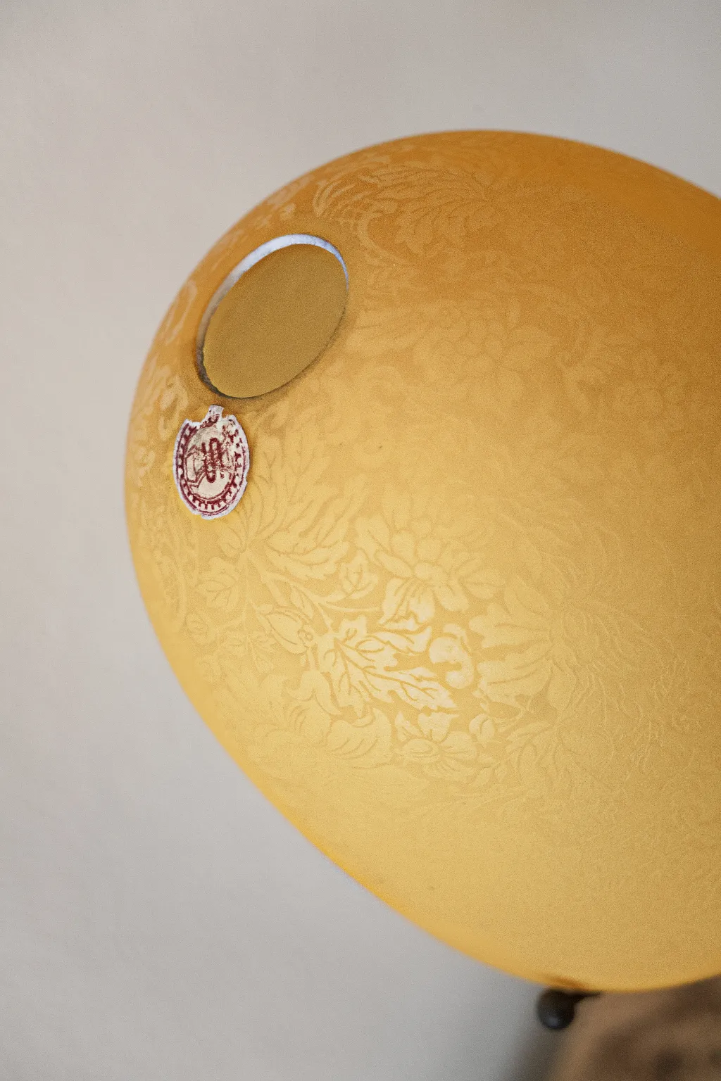 Lámpara de mesa antigua en color amarillo con diseño floral, ambiente acogedor.