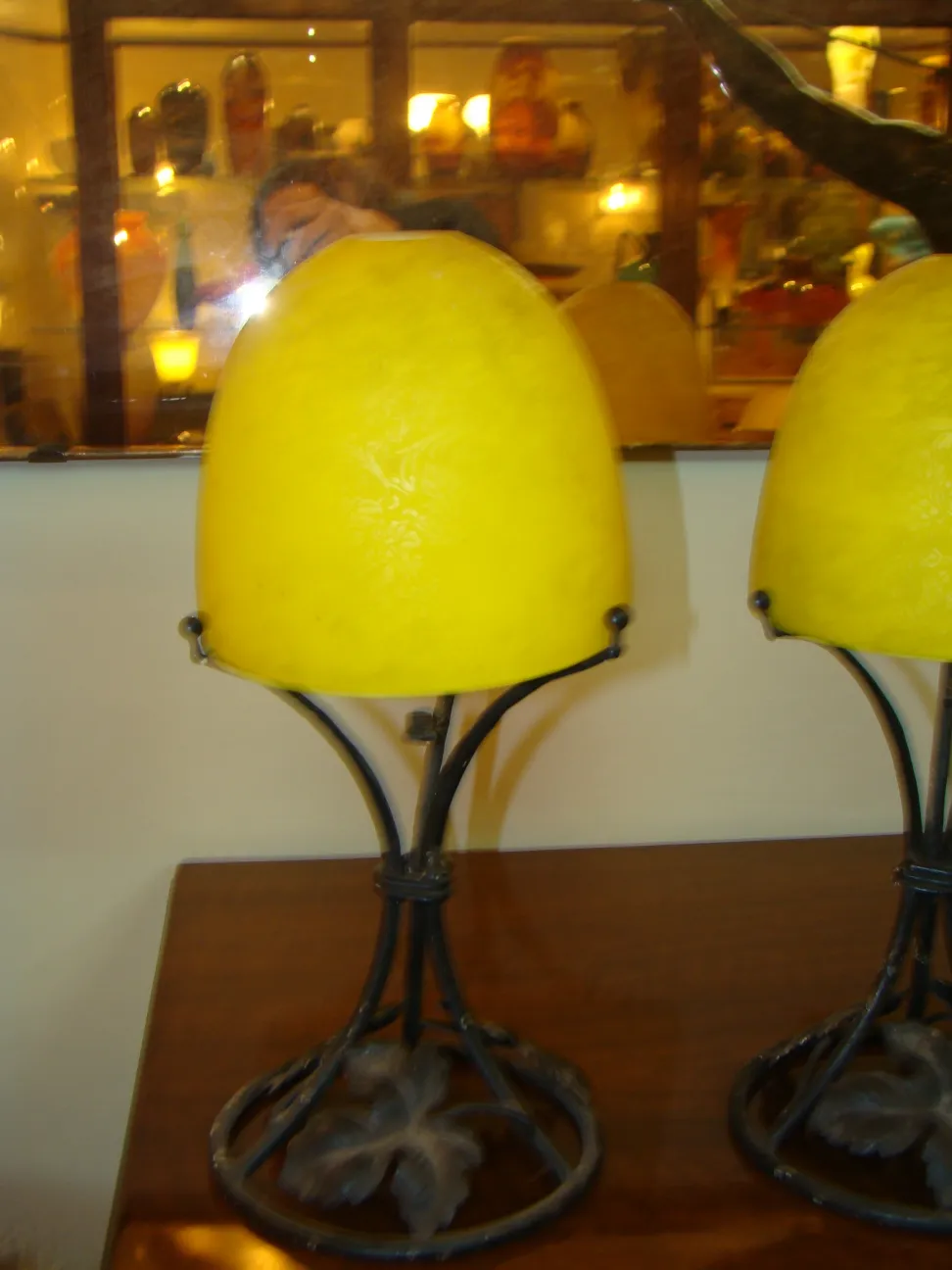 front view of an antique table lamp with yellow shade in a warm setting