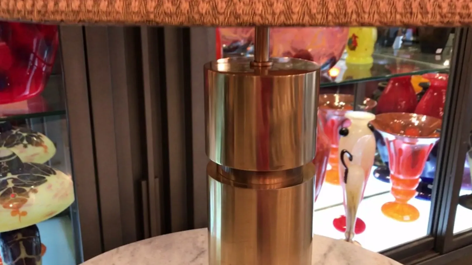 장식용 그림자가 있는 빈티지 테이블 램프, 다채로운 물체에 둘러싸여 있습니다.