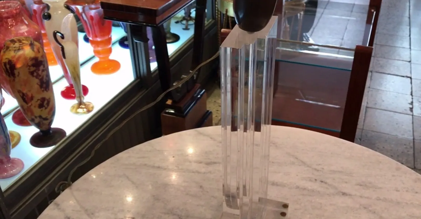 조각 같은 디자인의 앤티크 테이블 램프가 있는 편안한 환경에서 장식적인 물건에 둘러싸여 있습니다.