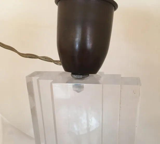 Lámpara de mesa antigua con base translúcida y diseño clásico.