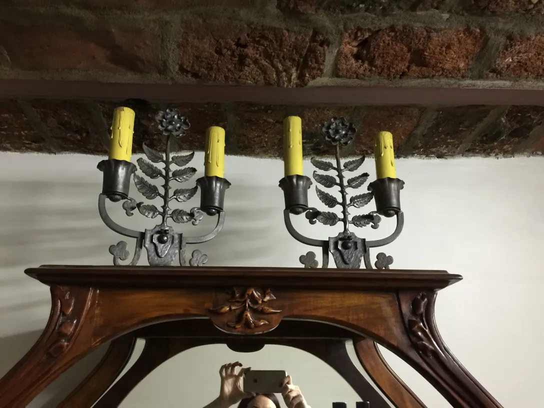 Antigua lámpara de mesa con diseño de hojas y velas amarillas, ambiente acogedor.