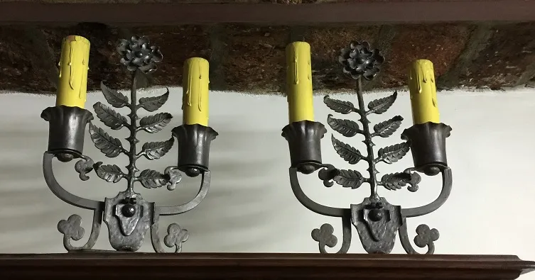 dos lámparas de mesa antiguas con formas de hojas y velas amarillas