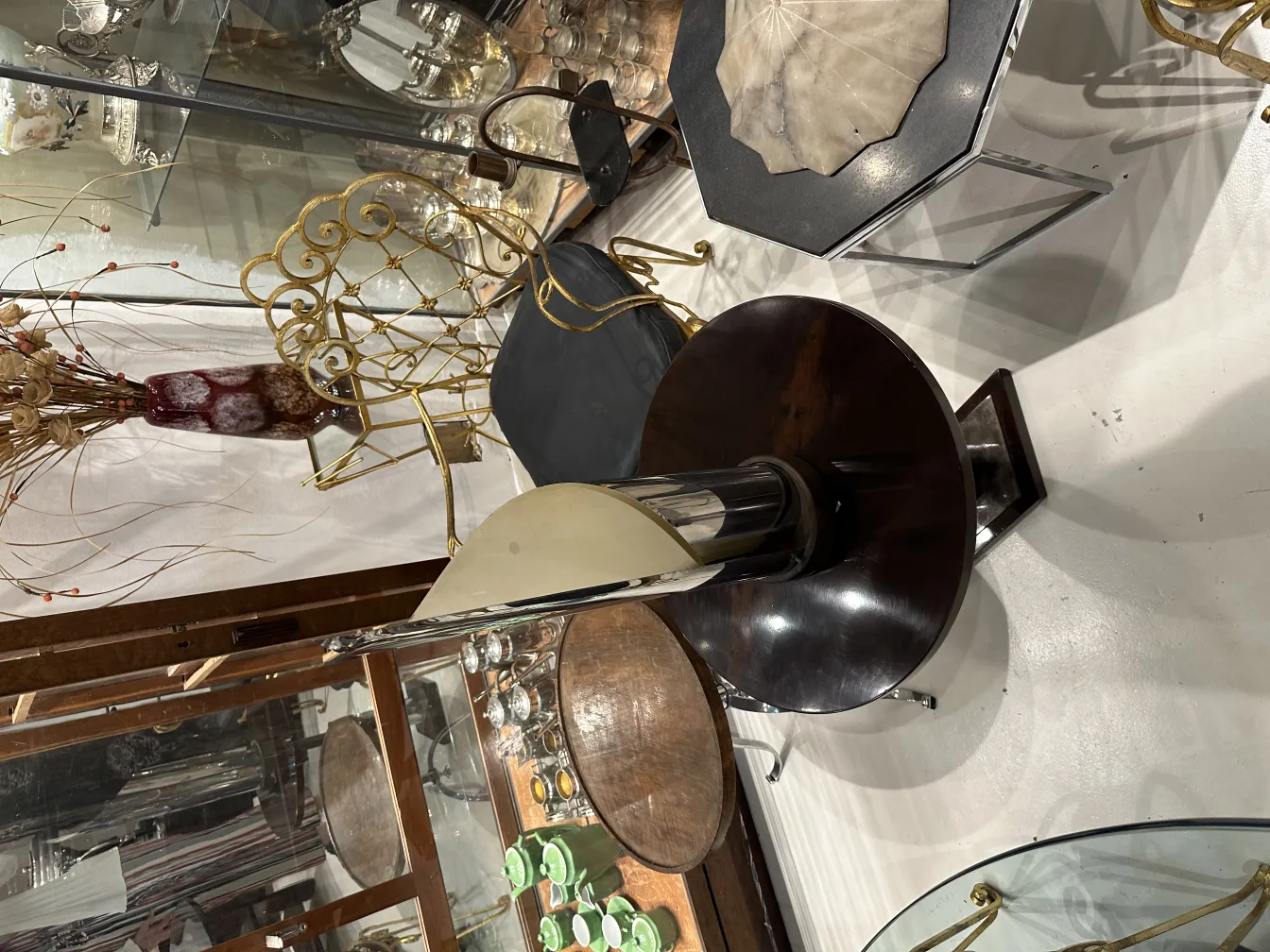 lampara de mesa antigua con base circular y pantalla modernista, en un entorno con decoraciones vintage