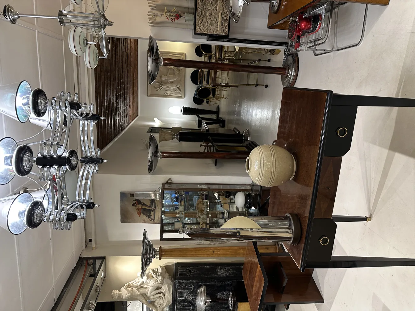 Lámpara de mesa antigua con base negra y detalles decorativos en un ambiente clásico.