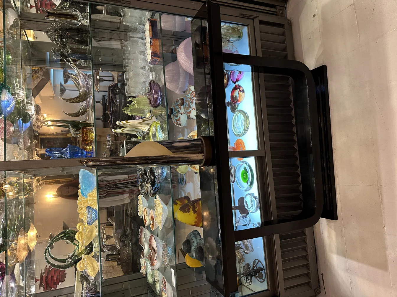 antike Tischlampe in einer Vitrine zusammen mit anderen Dekorationsartikeln