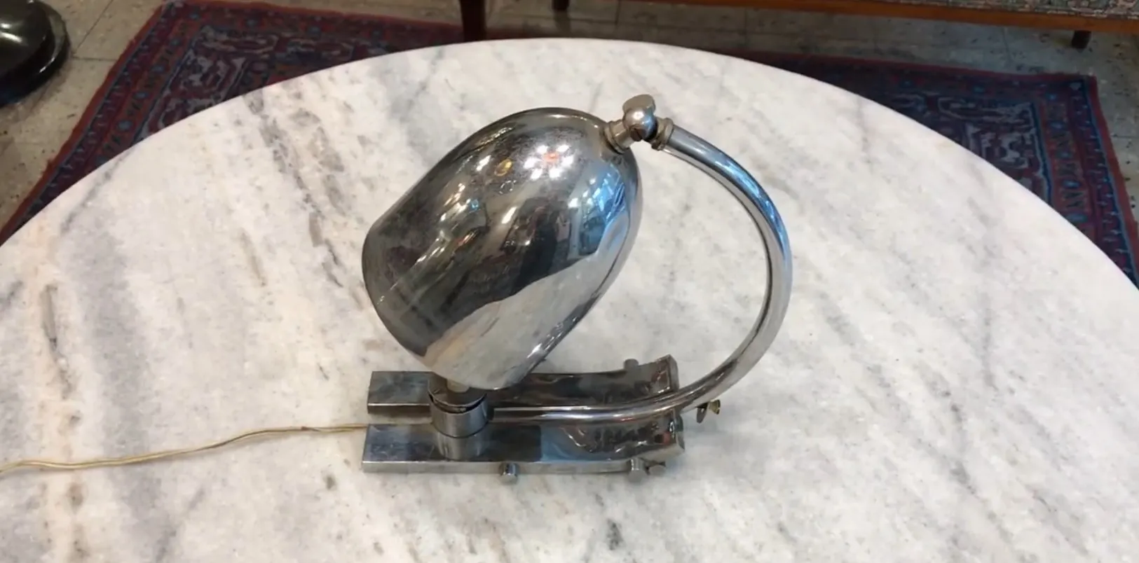 Antike glänzende Tischlampe mit metallischer Basis und elegantem Design, in einer gemütlichen Umgebung.