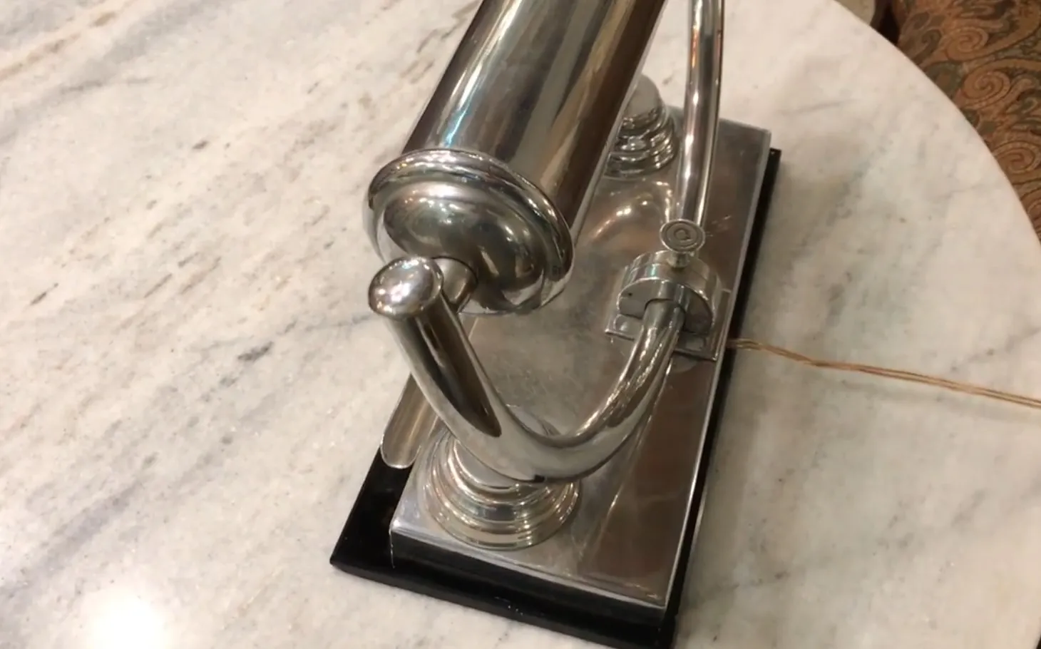 Luminária de mesa antiga brilhante com design elegante, fundo de mármore claro.