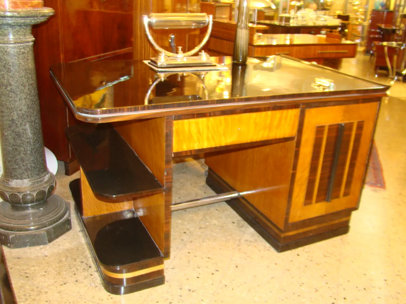 Luminária de mesa antiga com base de design único, iluminando uma mesa elegante.