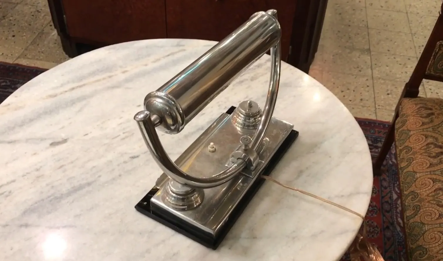 lampara de mesa antigua con base elegante y detalles brillantes, sobre mesa de mármol