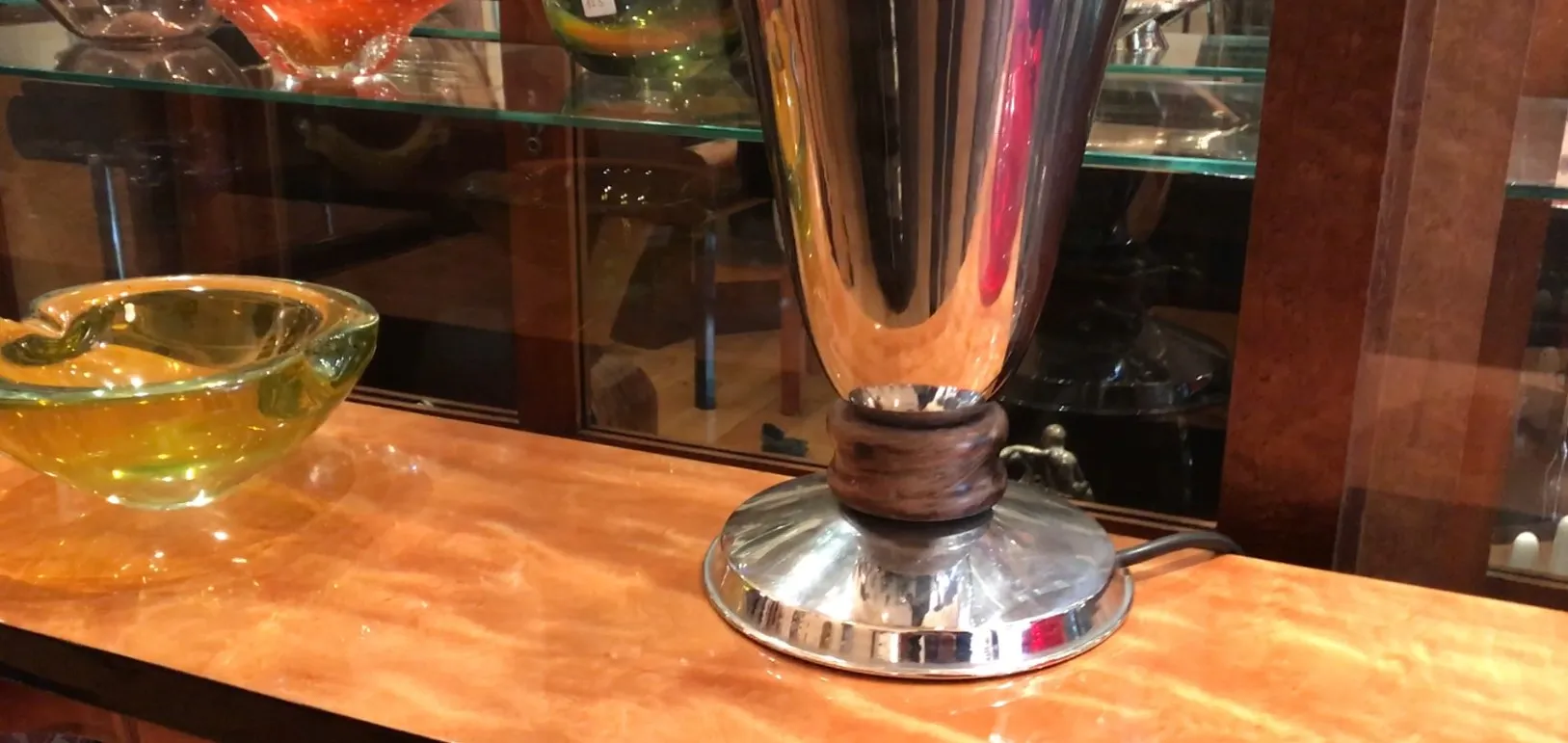 Lampada da tavolo antica con base lucida e supporto scuro.