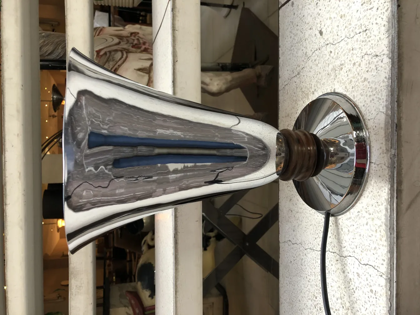 Lampada da tavolo antica con base lucida e forma elegante in un ambiente accogliente.