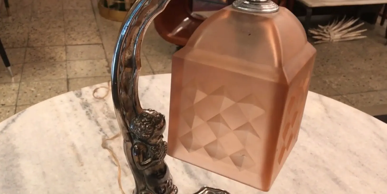 Antique table lamp with a figurine base, soft lighting.