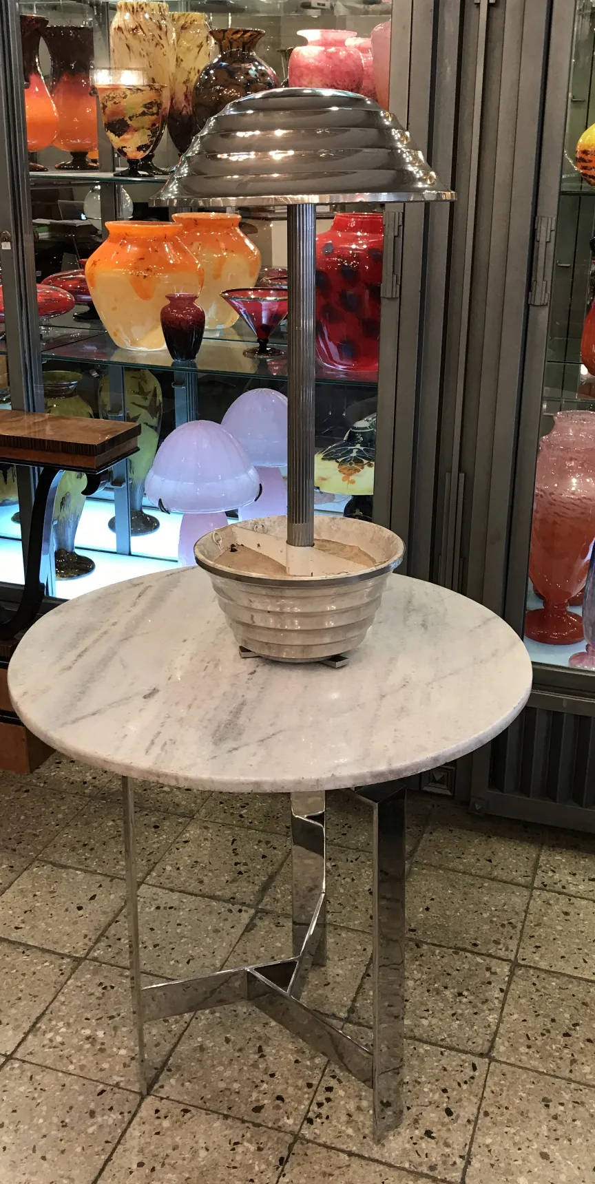 원형 기반의 앤틱 테이블 램프, 빈티지 장식으로 둘러싸여 있습니다.