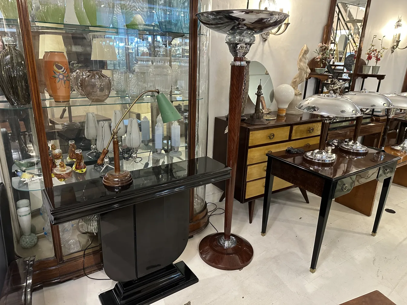 Lamp de bureau ancienne verte avec base en bois, dans une vitrine d'antiquités.