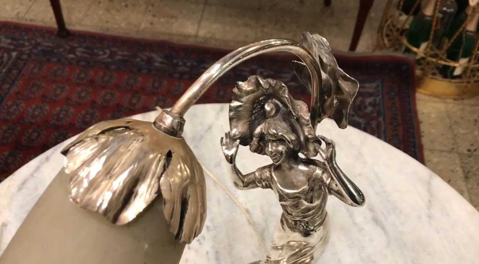 antiga luminária de mesa em um ambiente clássico, com detalhe de figura feminina