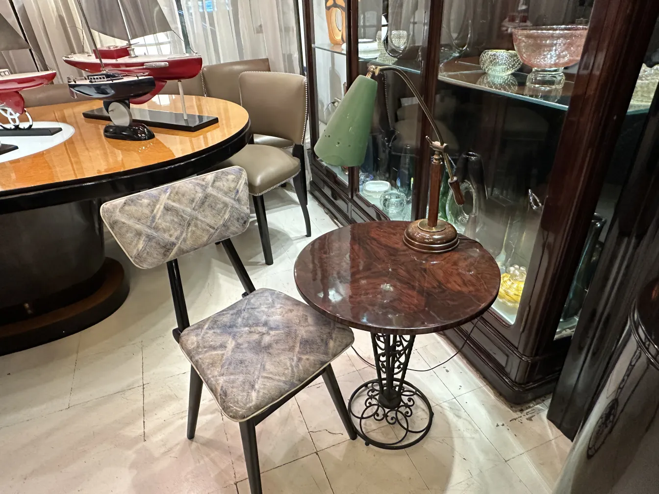 Antica lampada da tavolo con paralume verde e base in metallo, in un ambiente elegante.