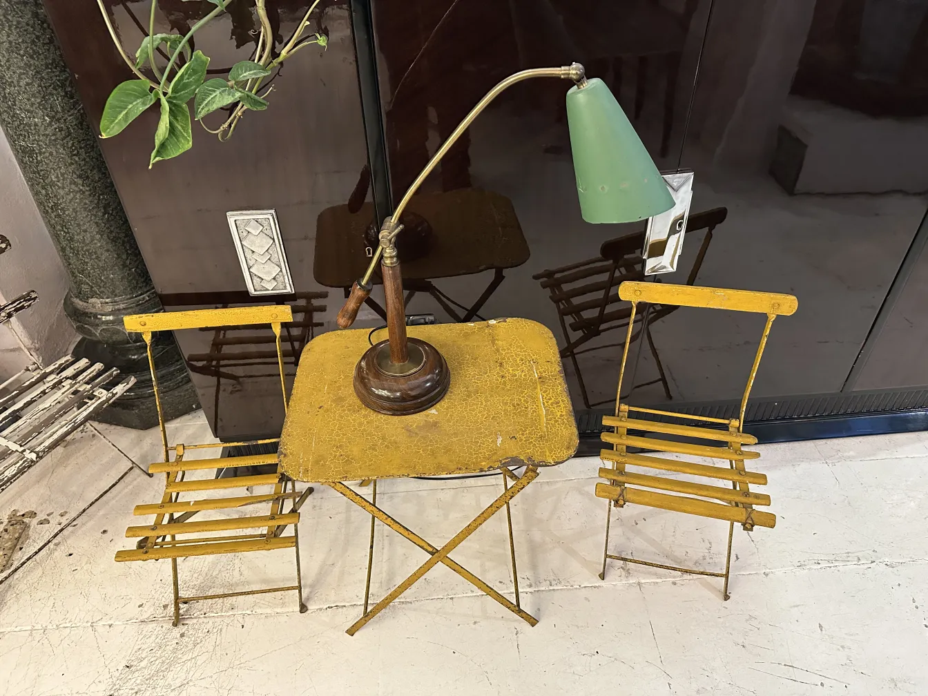 Lámpara de mesa antigua junto a sillas amarillas en salón