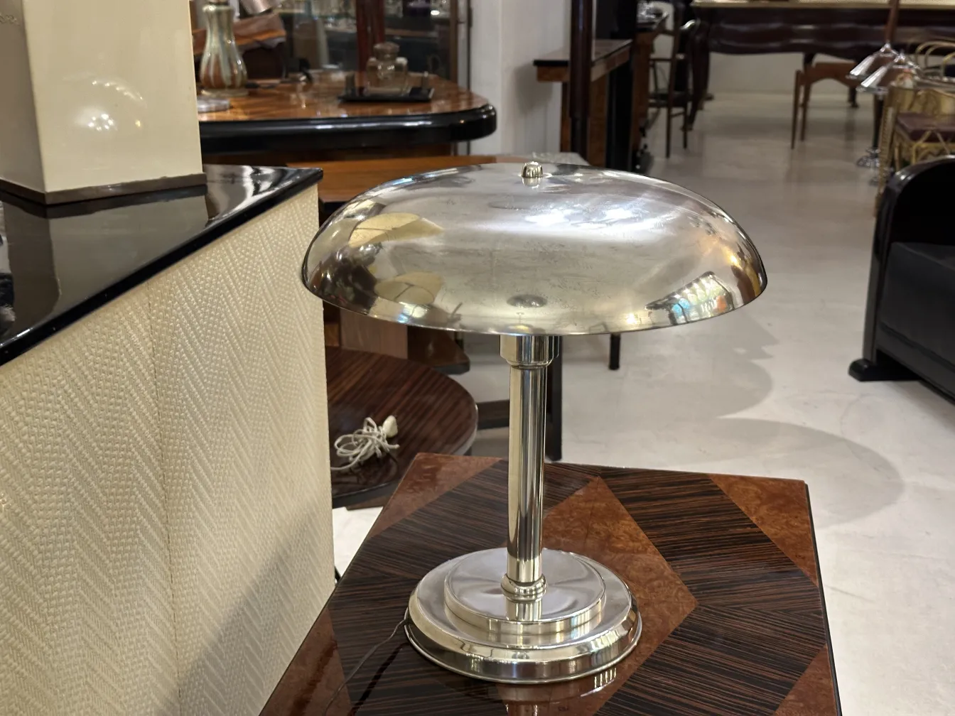 Luminária de mesa antiga com base brilhante e forma elegante. Ambiente aconchegante.