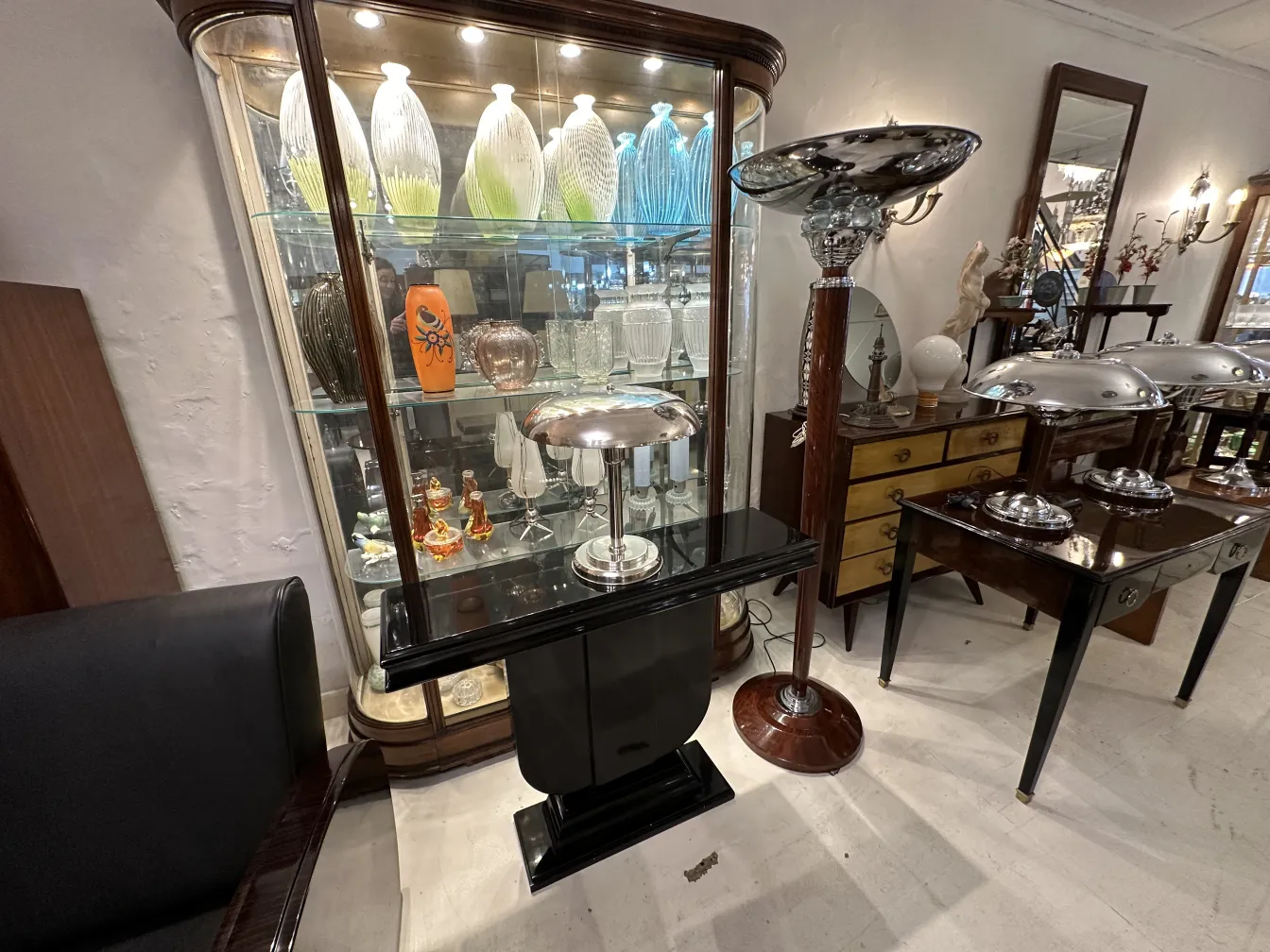 luminária de mesa antiga com base preta e acabamento prateado, parte de um ambiente clássico