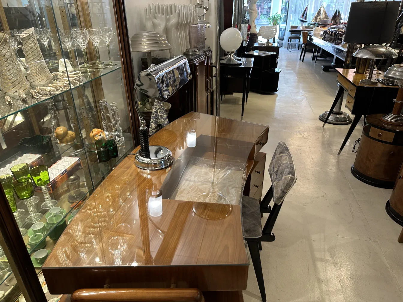 Luminária de mesa antiga em uma escrivaninha com itens decorativos.